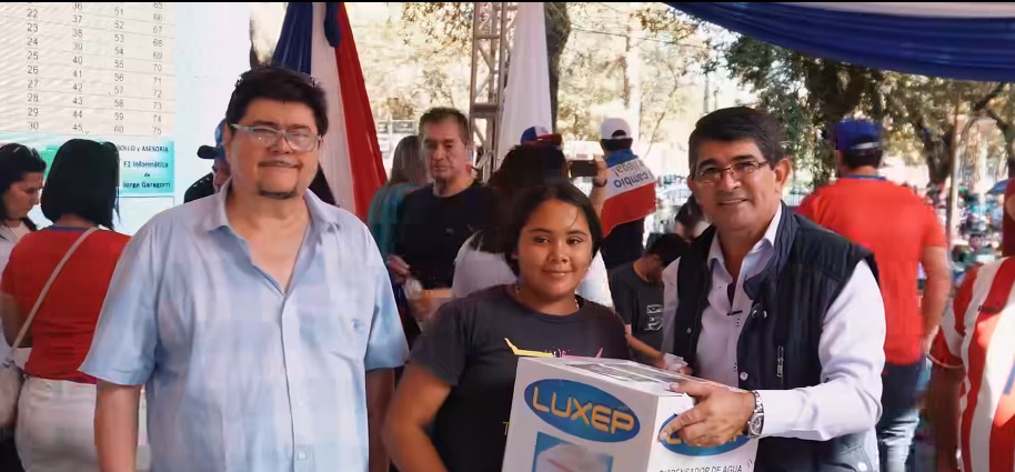 Oscar González Drákeford (derecha) entrega un premio durante un concurrido bingo realizado el 23 de abril de 2023, en Ciudad del Este. 